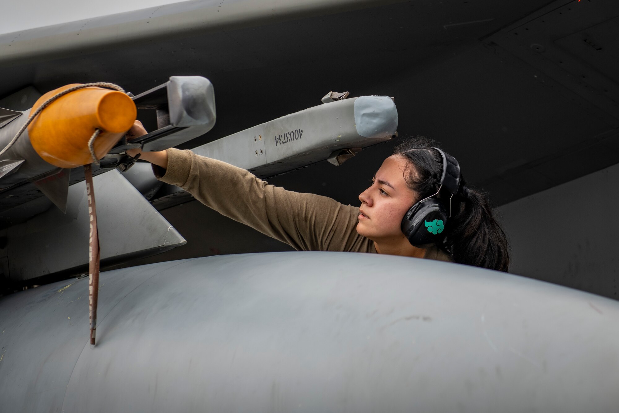 A maintainer loads a missile on an aircraft