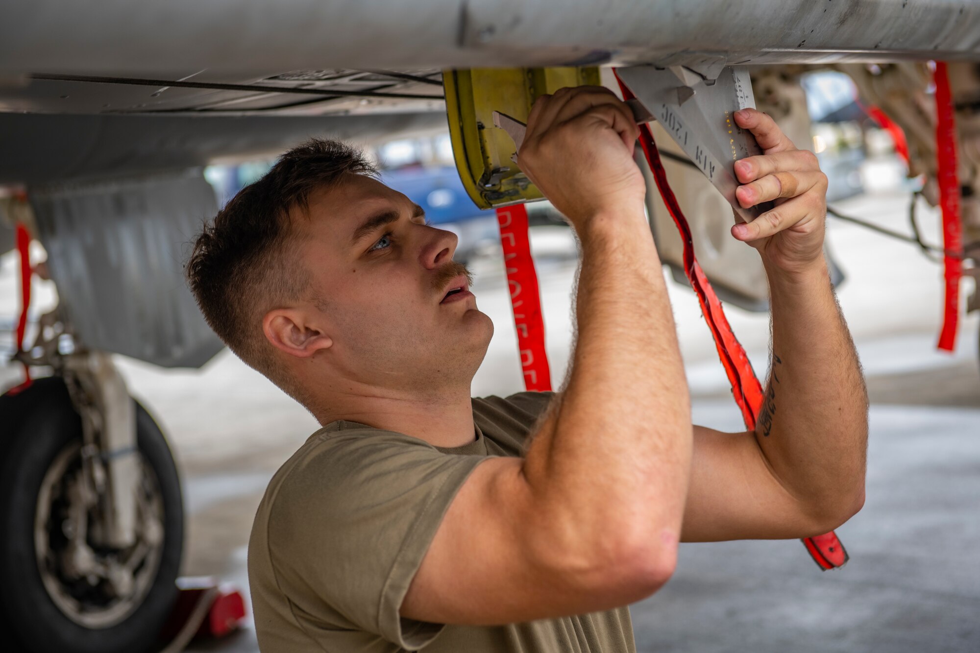 A maintainer performs maintenance on an aircraft