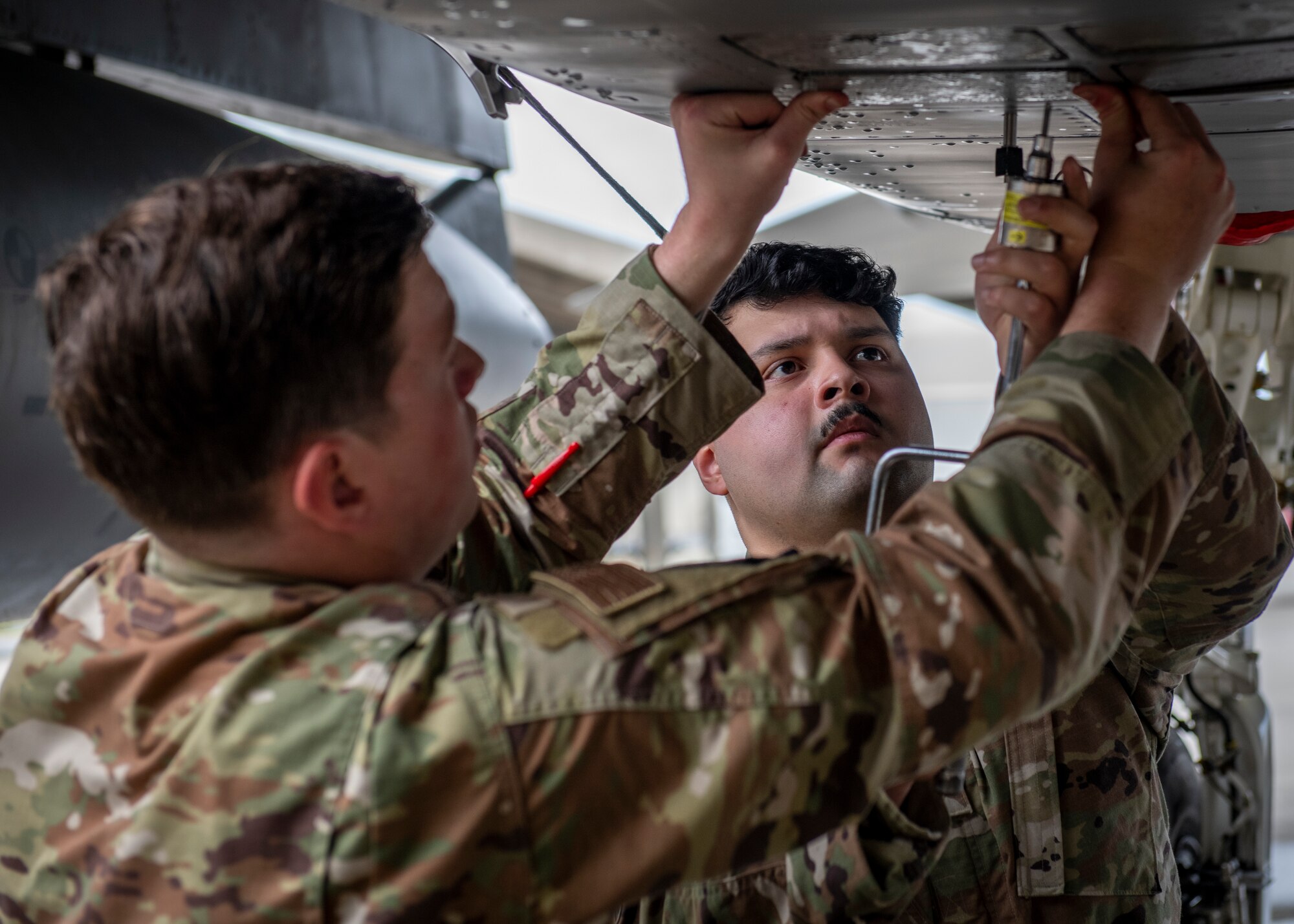 Maintainers perform maintenance on an aircraft