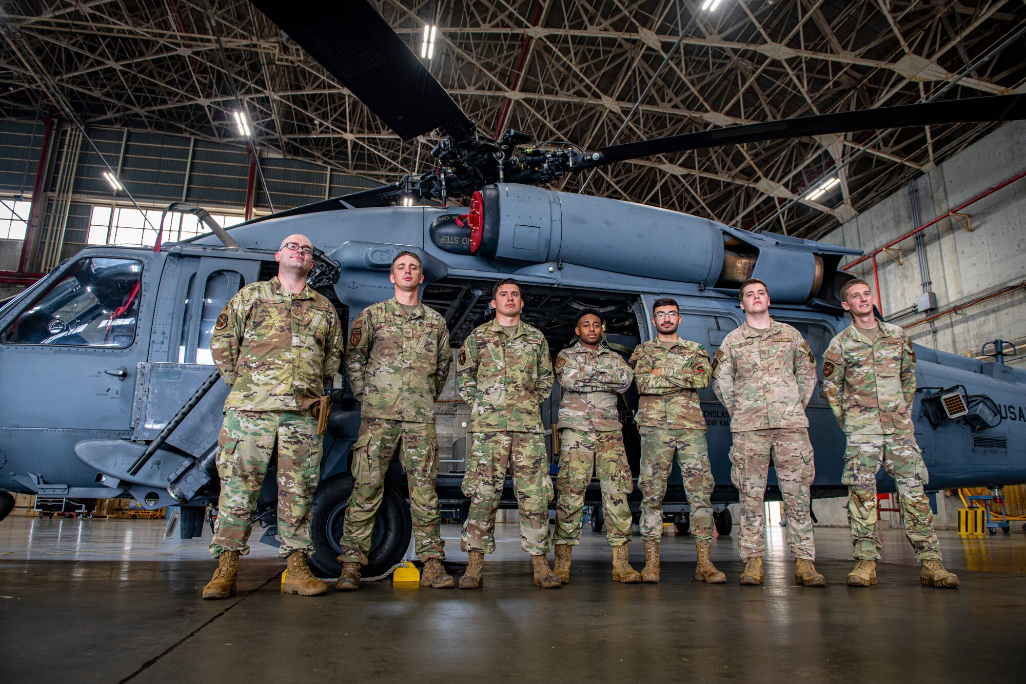 Maintainers pose in front of a helicopter