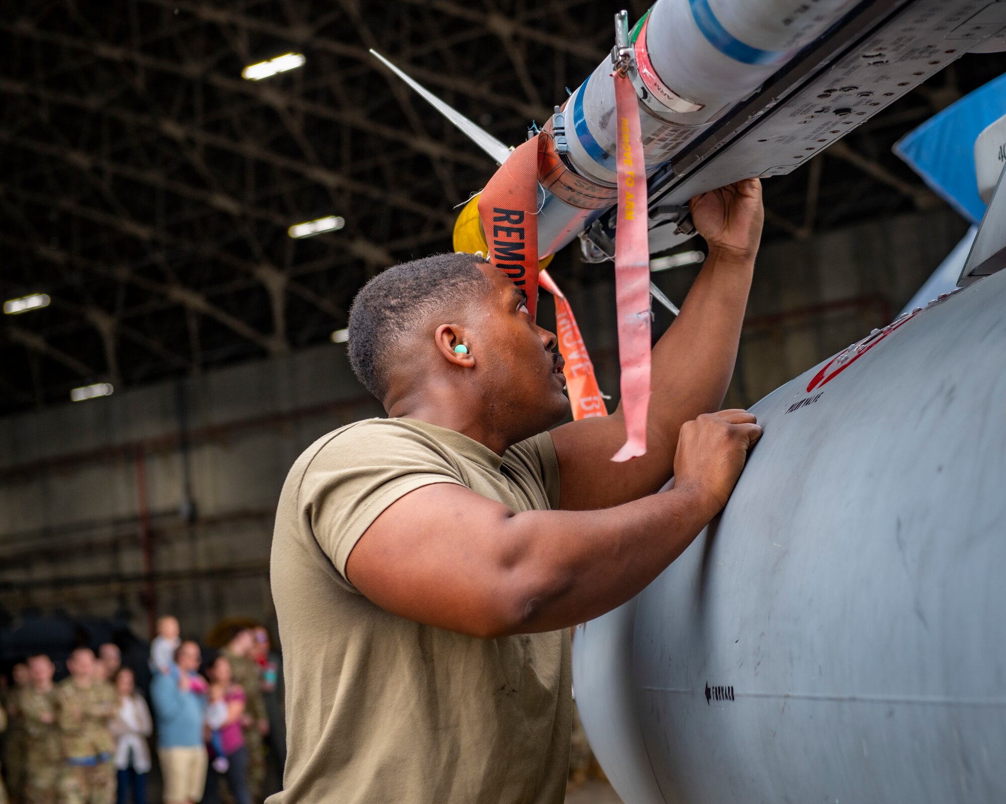 Maintainer loads a missile on an aircraft