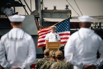 220321-N-KZ419-1415 MANAMA, Bahrain (March 21, 2022) Capt. Jeffery Baker, commander of Naval Surface Squadron Five, delivers remarks in front of patrol coastal ship USS Whirlwind (PC 11) during the ship's decommissioning ceremony March 21, at Naval Support Activity Bahrain.
