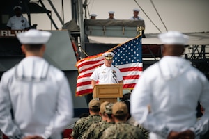 220321-N-KZ419-1415 MANAMA, Bahrain (March 21, 2022) Capt. Jeffery Baker, commander of Naval Surface Squadron Five, delivers remarks in front of patrol coastal ship USS Whirlwind (PC 11) during the ship's decommissioning ceremony March 21, at Naval Support Activity Bahrain.