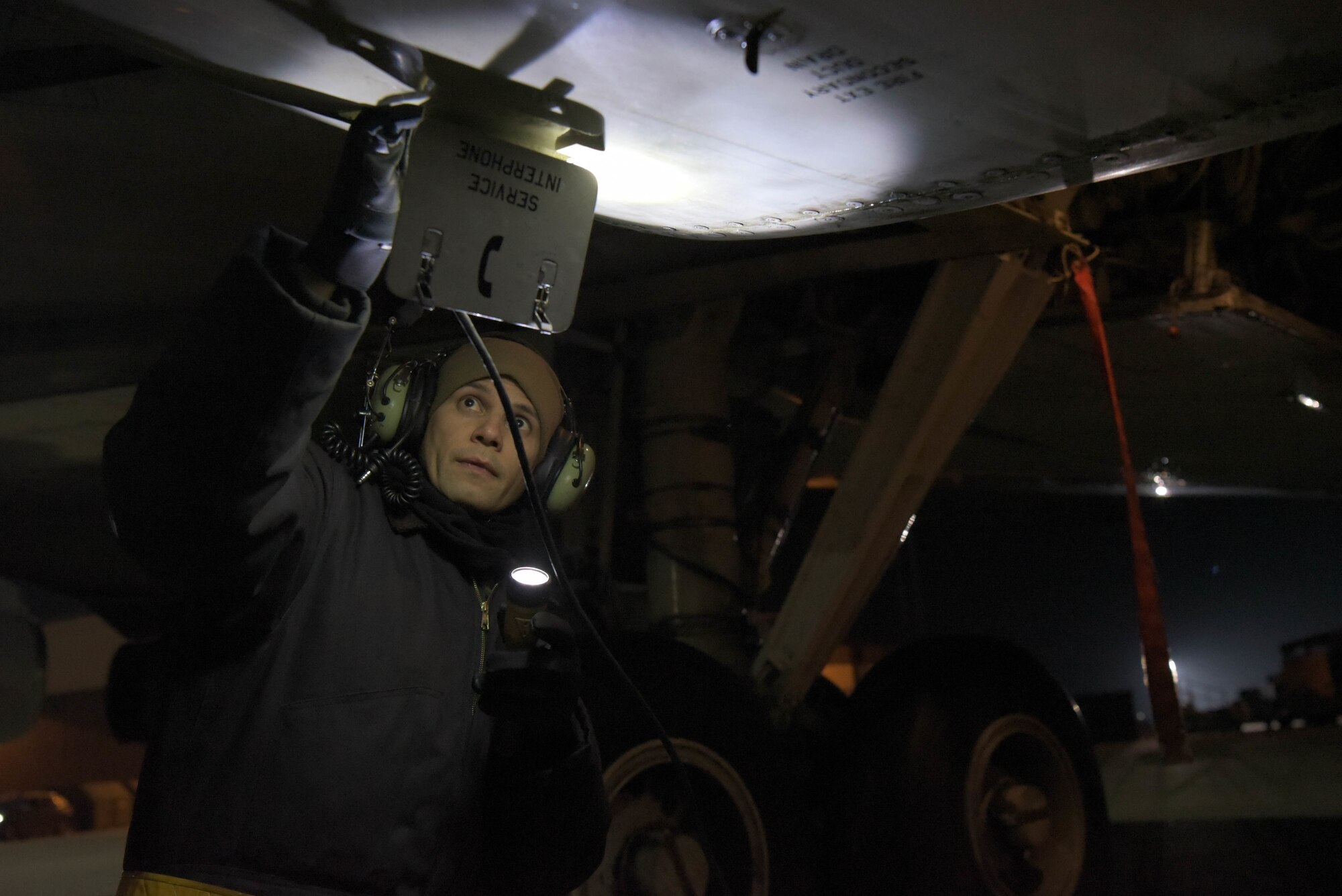 U.S. Air Force Airman inspects aircraft in the dark