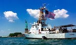 The Coast Guard Cutter Cushing sails past the Statue of Liberty in New York City.