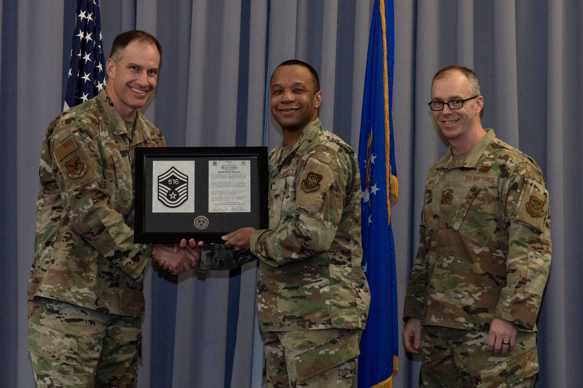 Master Sgt. Phenice Cooper, center, 436th Aerial Port Squadron traffic management superintendent, accepts his senior master sergeant promotion plaque from Col. Matt Husemann, left, 436th Airlift Wing commander, and Chief Master Sgt. Timothy Bayes, 436th AW command chief, during the senior master sergeant promotion release party at Dover Air Force Base, Delaware, March 18, 2022. Cooper was one of seven master sergeants at Dover AFB selected for promotion to senior master sergeant in the 22E8 promotion cycle. (U.S. Air Force photo by Roland Balik)