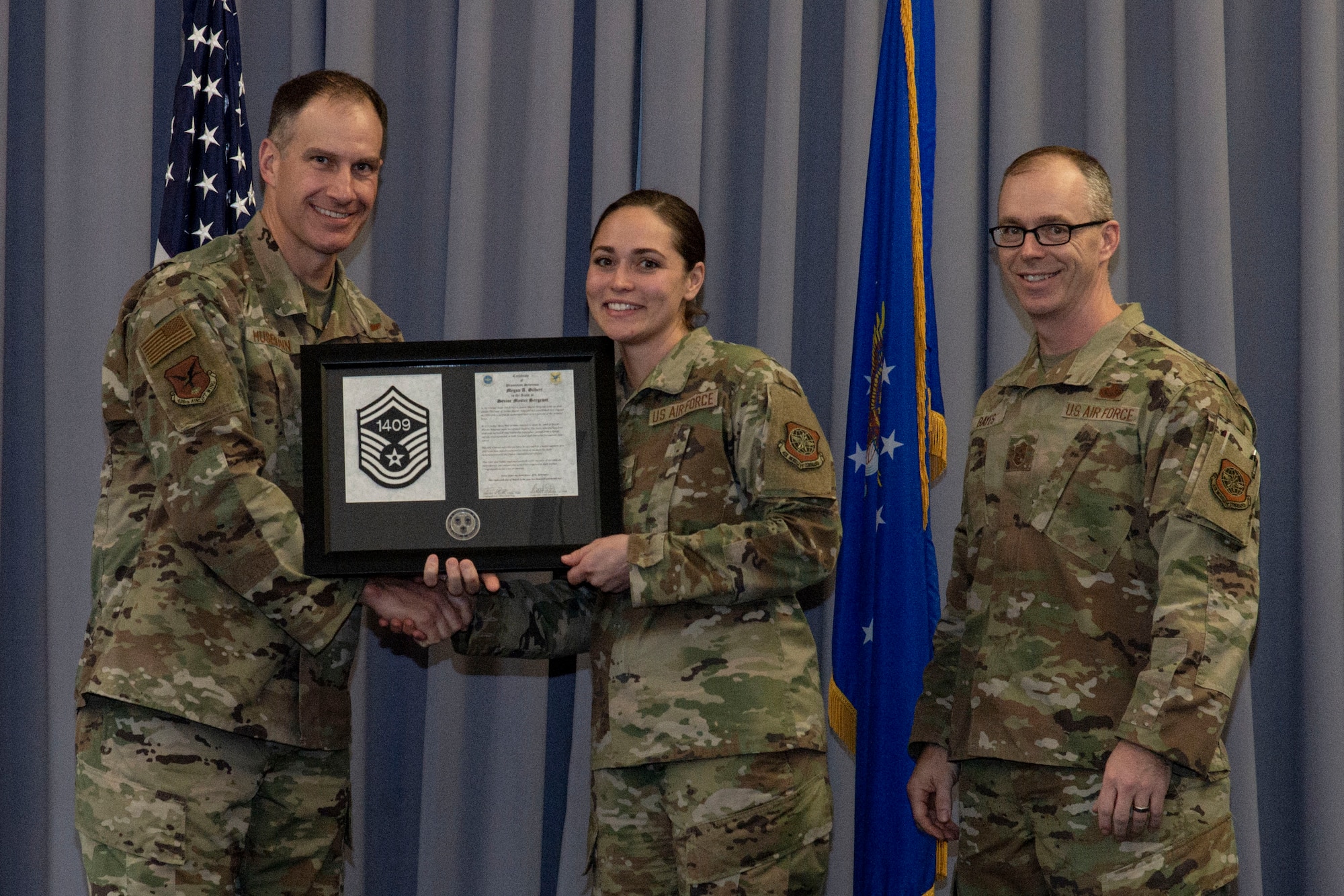 Master Sgt. Meagan Gilbert, center, 436th Maintenance Group maintenance training element chief, accepts her senior master sergeant promotion plaque from Col. Matt Husemann, left, 436th Airlift Wing commander, and Chief Master Sgt. Timothy Bayes, 436th AW command chief, during the senior master sergeant promotion release party at Dover Air Force Base, Delaware, March 18, 2022. Gilbert was one of seven master sergeants at Dover AFB selected for promotion to senior master sergeant in the 22E8 promotion cycle. (U.S. Air Force photo by Roland Balik)