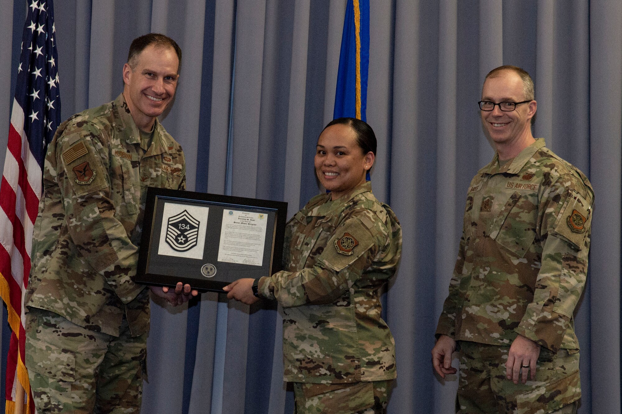 Master Sgt. Jaerynne Rose, center, 436th Operations Support Squadron weather flight chief, accepts her senior master sergeant promotion plaque from Col. Matt Husemann, left, 436th Airlift Wing commander, and Chief Master Sgt. Timothy Bayes, 436th AW command chief, during the senior master sergeant promotion release party at Dover Air Force Base, Delaware, March 18, 2022. Rose was one of seven master sergeants at Dover AFB selected for promotion to senior master sergeant in the 22E8 promotion cycle. (U.S. Air Force photo by Roland Balik)