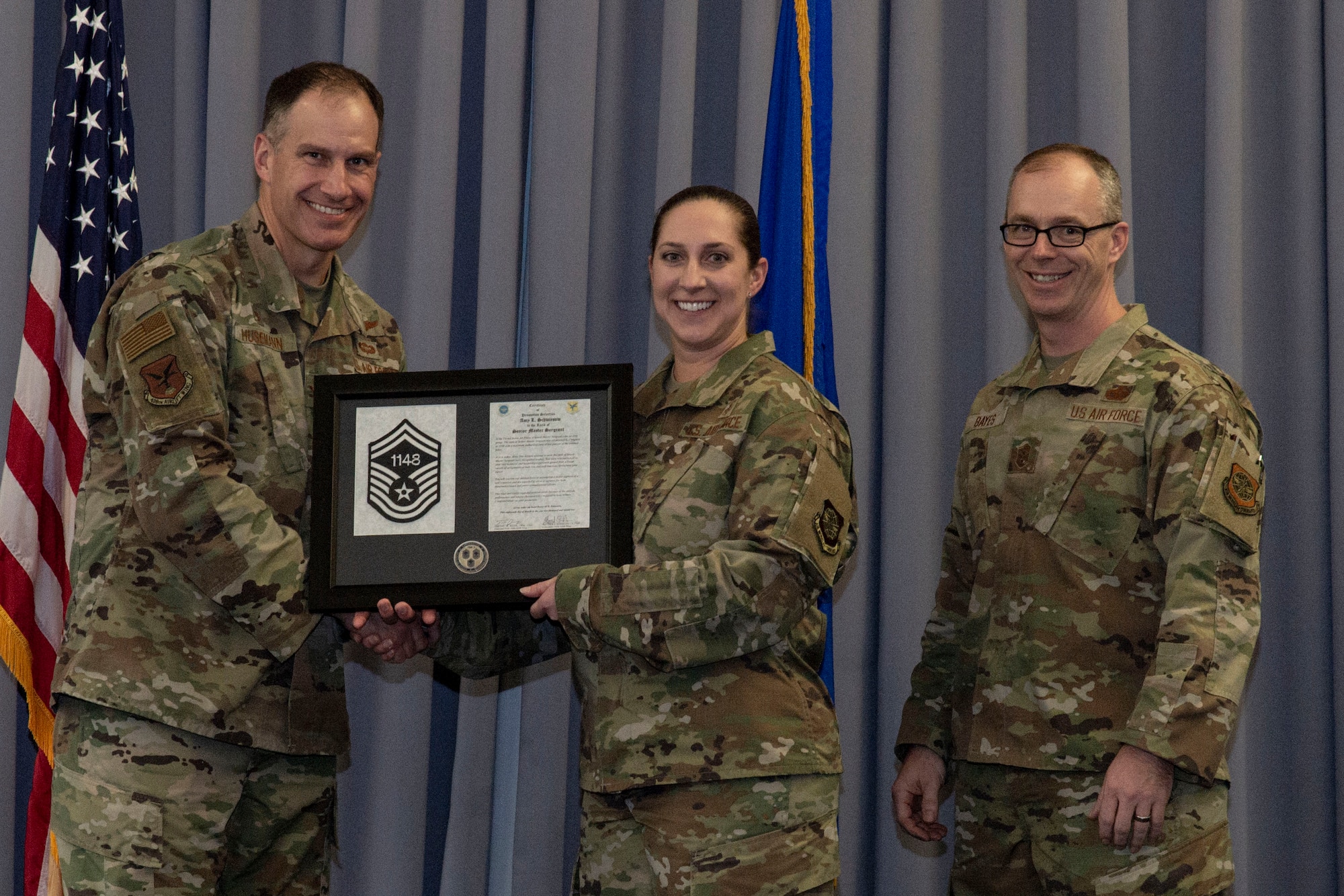 Master Sgt. Amy Schwiesow, center, 436th Medical Support Squadron senior enlisted leader, accepts her senior master sergeant promotion plaque from Col. Matt Husemann, left, 436th Airlift Wing commander, and Chief Master Sgt. Timothy Bayes, 436th AW command chief, during the senior master sergeant promotion release party at Dover Air Force Base, Delaware, March 18, 2022. Schwiesow was one of seven master sergeants at Dover AFB selected for promotion to senior master sergeant in the 22E8 promotion cycle. (U.S. Air Force photo by Roland Balik)