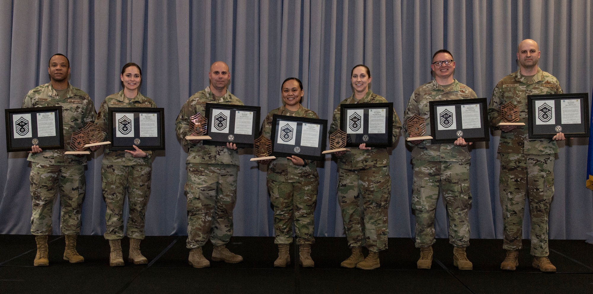 From the left, Master Sgts. Phenice Cooper, 436th Aerial Port Squadron traffic management superintendent; Meagan Gilbert, 436th Maintenance Group maintenance training element chief; Jared Hess, 736th Aircraft Maintenance Squadron aircraft inspection section chief; Jaerynne Rose, 436th Operations Support Squadron weather flight chief; Amy Schwiesow, 436th Medical Support Squadron senior enlisted leader; Michael Vaughn, 436th Maintenance Squadron munitions flight chief; and Arik Wexler, 736th Aircraft Maintenance Squadron C-17 lead production superintendent; pose for a photo at the conclusion of the senior master sergeant promotion release party at Dover Air Force Base, Delaware, March 18, 2022. The seven master sergeants were selected for promotion to senior master sergeant in the 22E8 promotion cycle. (U.S. Air Force photo by Roland Balik)