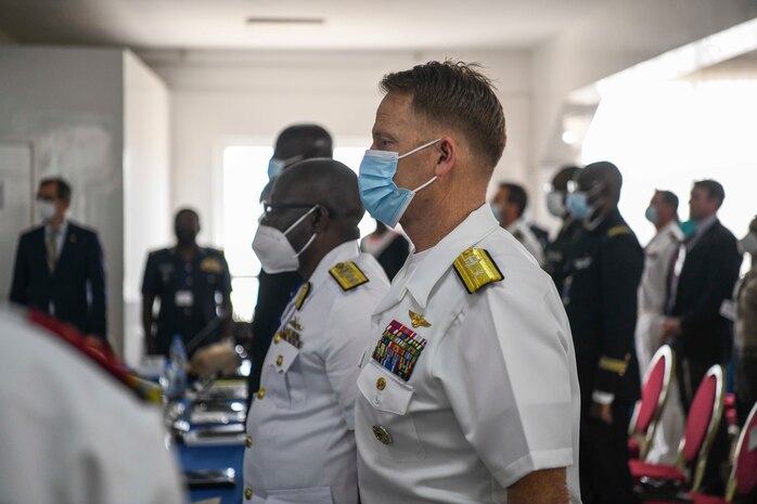 Rear Adm. Benjamin Reynolds, director of Maritime Headquarters, U.S. Naval Forces Europe and Africa, stands at attention during the Senegalese national anthem during the closing ceremony of Exercise Obangame Express 2022 at the Senegalese Naval Headquarters, in Dakar, Senegal, Mar. 18, 2022.