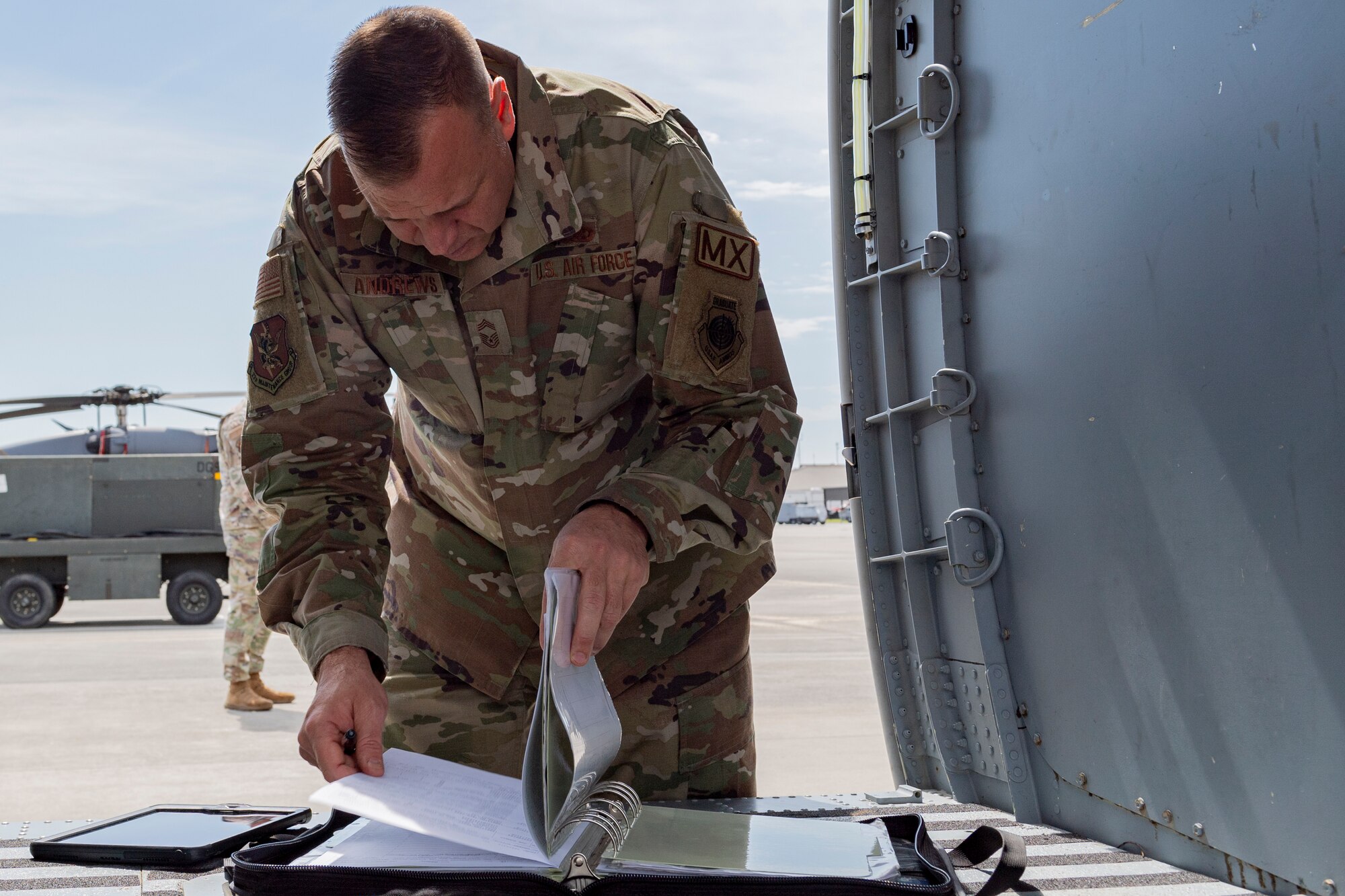 Photo of an Airman inspecting a maintenance binder