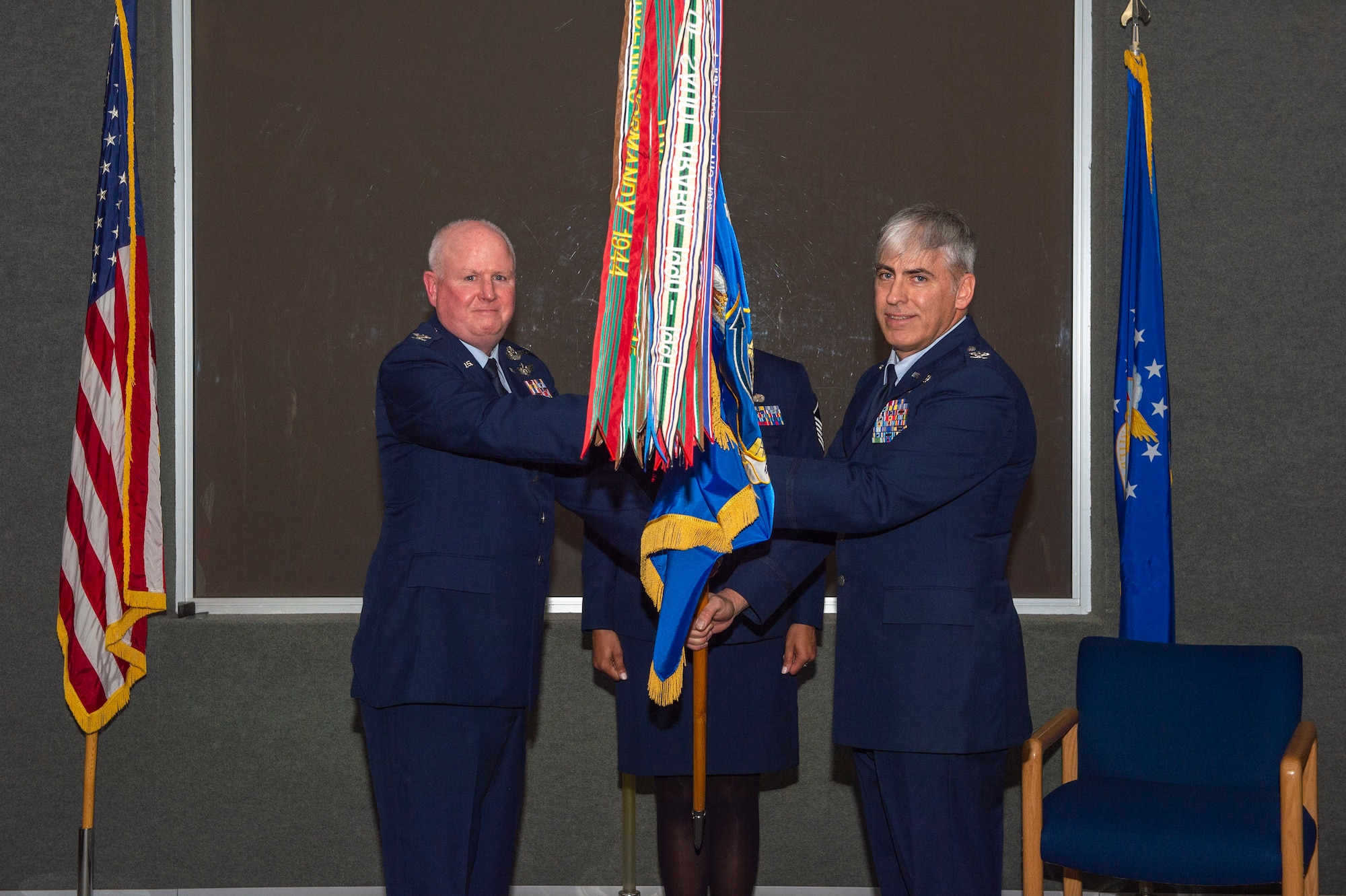 Col. Thomas Pemberton, 434th Air Refueling Wing commander, hands the guidon of the 434th Operations Group to Col. Douglas Perry Jr. at Gus Grissom Hall on Grissom Air Reserve Base, Ind., Mar. 6. Perry received command of the group during a dual ceremony in which he pinned on the rank of colonel as well. (U.S. Air Force photo by Staff Sgt. Michael Hunsaker)