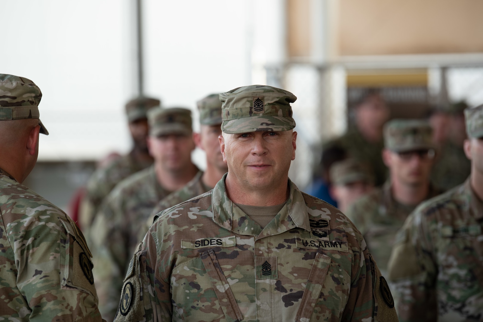 Members of the 404th Maneuver Enhancement Brigade wait to receive their combat patch,