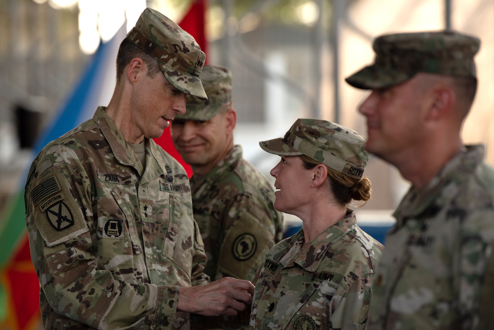 Maj. Gen. William Zana, commanding general of Combined Joint Task Force - Horn of Africa (CJTF-HOA), places newly earned combat patches, a military milestone earned while serving in hostile conditions, on members of the 404th Maneuver Enhancement Brigade,