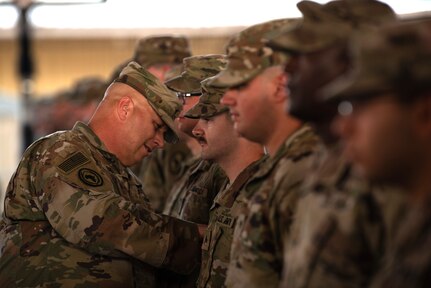 Members of the 404th Maneuver Enhancement Brigade receive their combat patch, a military milestone earned while serving in hostile conditions, March 17, 2022.