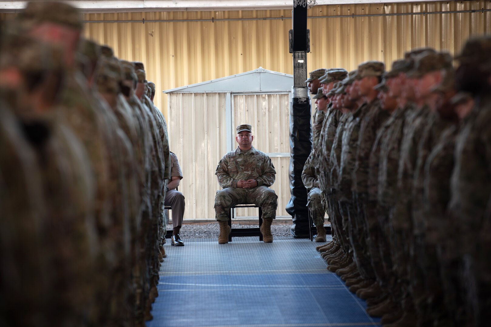 Command Chief Master Sgt. Jason Colón, Combined Joint Task Force - Horn of Africa command senior enlisted leader, observes as members of the 404th Maneuver Enhancement Brigade wait to receive their combat patches