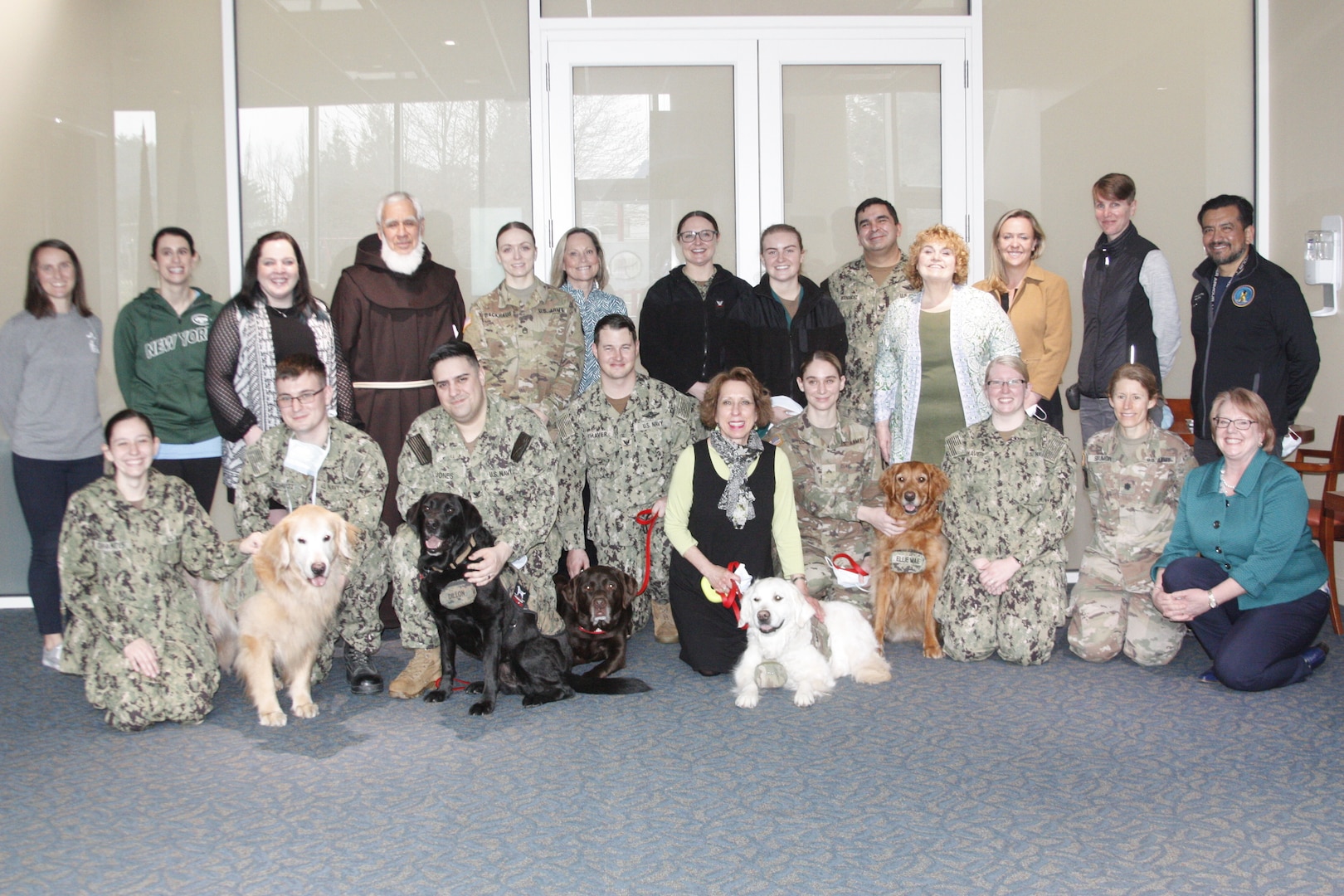 Canines and their handlers who are a part of the Facility Dog Program at Walter Reed National Military Medical Center gather to bid farewell to Army Maj. Annie Fox, a mix-breed Labrador and Golden Retriever, during a special retirement ceremony March 17 in the National Intrepid Center of Excellence at WRNMMC.