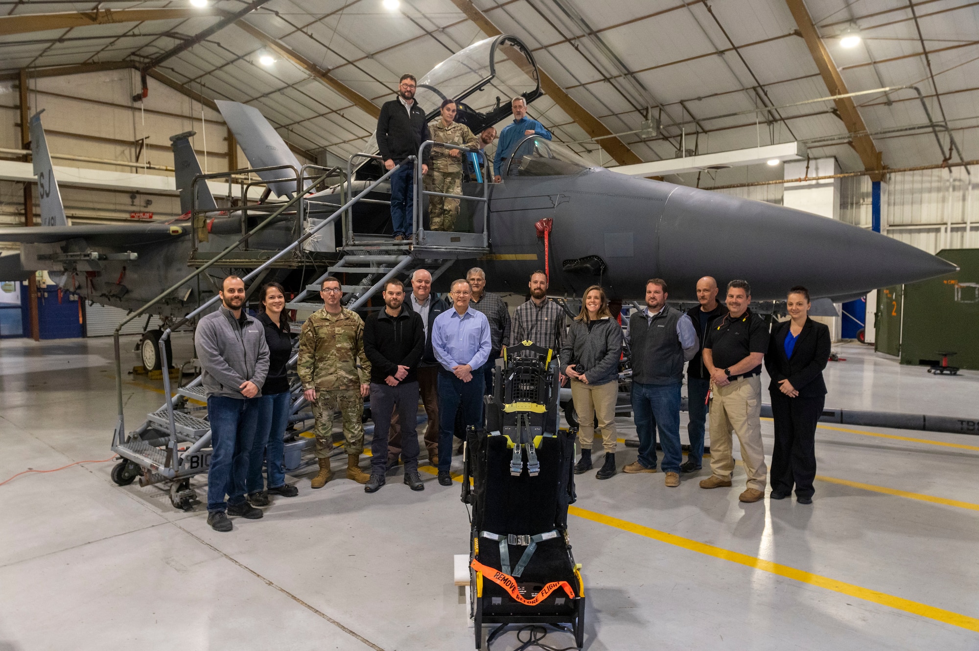 Airmen from the 4th Fighter Wing and engineers contracted by the U.S. Air Force pose for a photo with an F-15E Strike Eagle at Seymour Johnson Air Force Base, North Carolina, March 14, 2022. These Airmen and engineers are test fitting new ejection seats to the Strike Eagle for replacement of the current ejection seats. The Advanced Concept Ejection Seat 5 ejection seat will replace the F-15E's older ACES II ejection seat, which is used in many other aircraft in the U.S. Air Force’s arsonal. (U.S. Air Force photo by Senior Airman Kevin Holloway)