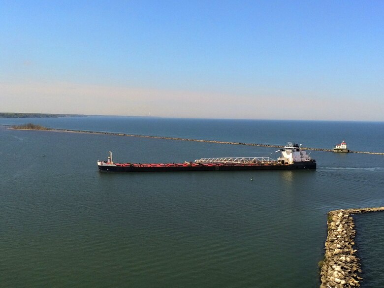 A lake freighter sails through a federal navigation channel in a harbor on Lake Erie.