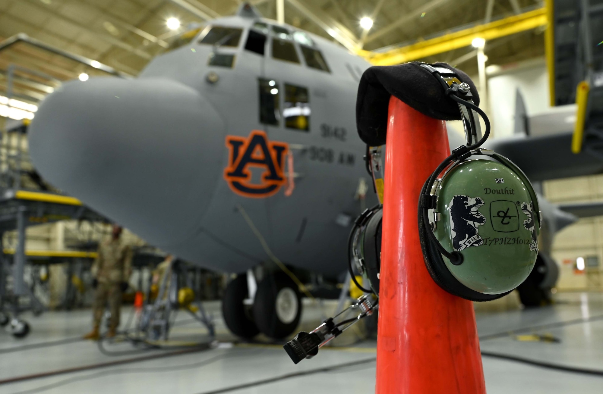 a crew chief’s headset sits in front of one of the 908th Airlift Wing’s C-130H Hercules while it is in the isochronal inspection hangar