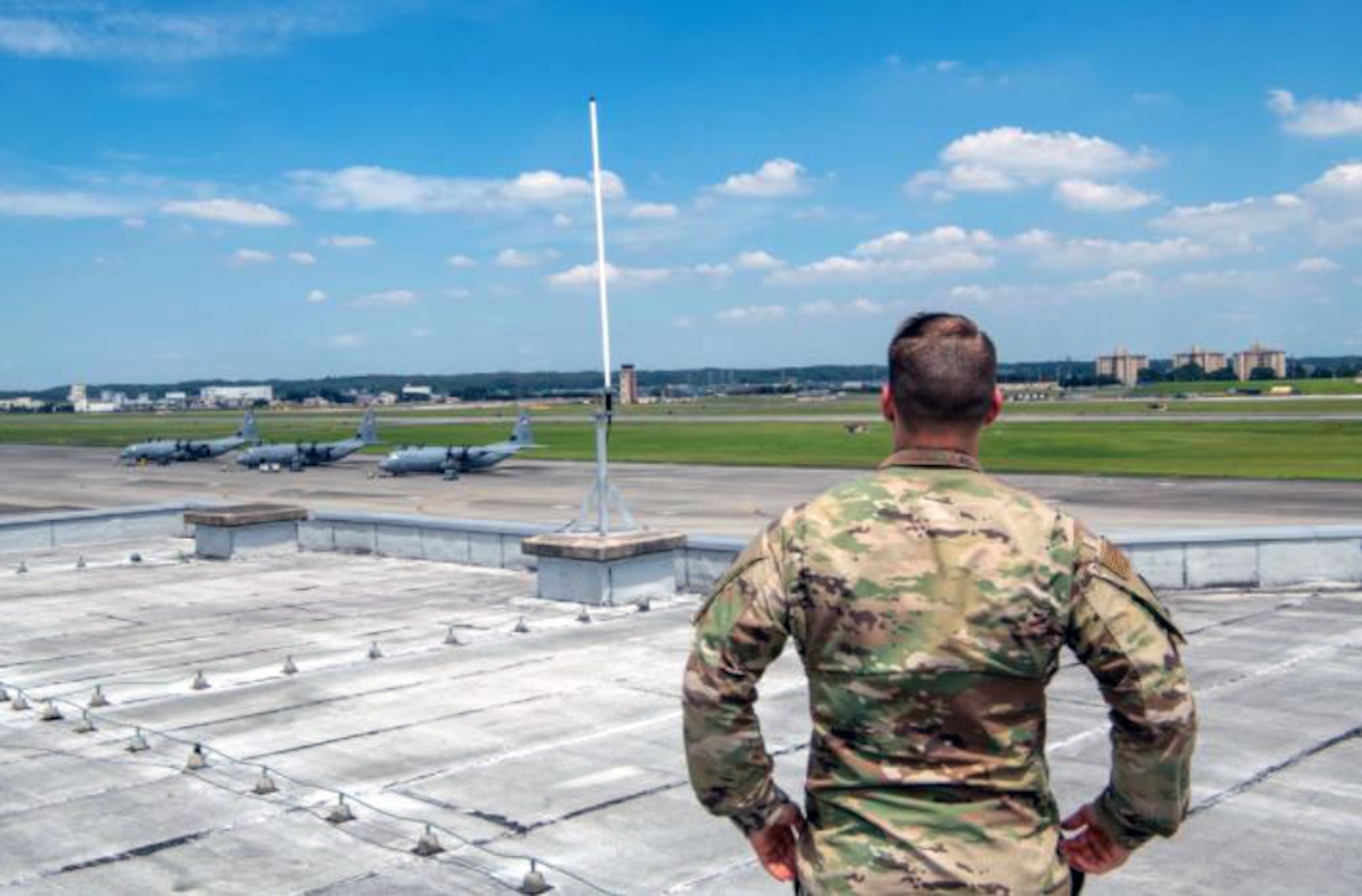 Tech. Sgt. Michael Clevenger, a weather forecaster with the 374th Operations Support Squadron, surveys weather sensors above a flight line at Yokota Air Base, Japan, in August 2021. Weather Systems Branch personnel at Hanscom Air Force Base, Mass. are currently preparing to launch the Air Force Weather - Bridging Environmental Intelligence For Responsive Operational Support Portal, or AFW - BIFROST Portal, which will provide Department of Defense users with a customizable environmental weather intelligence dashboard. (U.S. Air Force photo by Staff Sgt. Brendan Miller)
