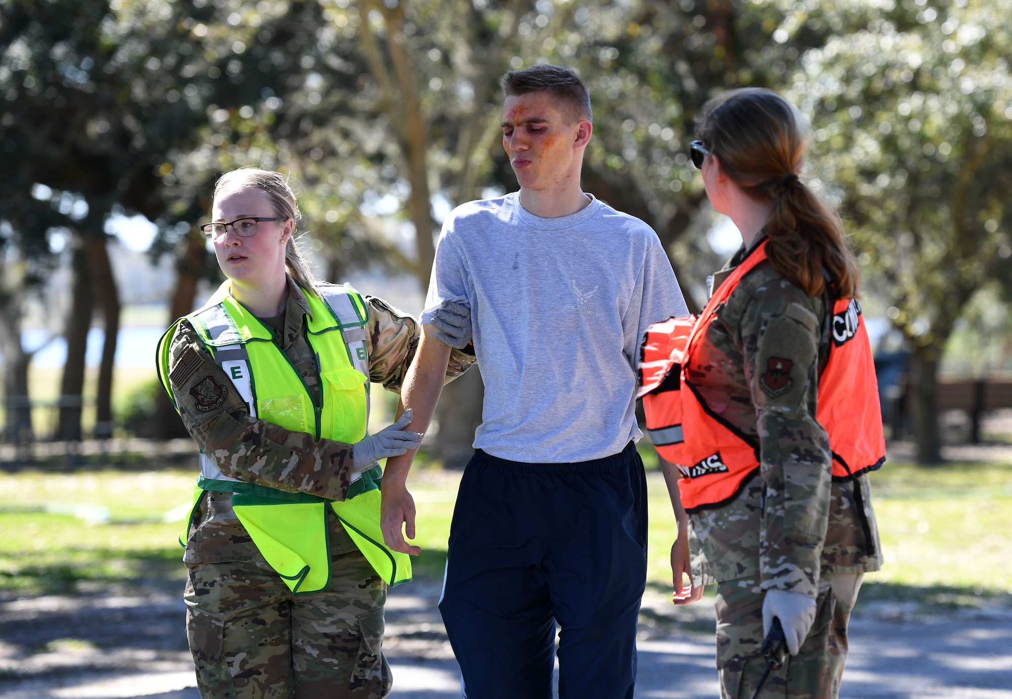 U.S. Air Force Senior Airman Megan Crow-Elmore and Staff Sgt. Ashley Dena, 81st Operational Medical Readiness Squadron medical technicians, escort Airman 1st Class Mason Westfall, 334th Training Squadron student, as he portrays a victim to the triage area for medical attention during an Antiterrorism, Force Protection and Chemical, Biological, Radiological, Nuclear exercise at Keesler Air Force Base, Mississippi, March 17, 2022. The exercise tested the base's ability to respond to and recover from a mass casualty event. (U.S. Air Force photo by Kemberly Groue)