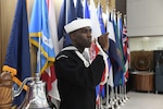Boatswain's Mate Second Class Lorenzo Jordan pipes the bosun's whistle to symbolize the launch of MHS GENESIS at Naval Medical Center Camp Lejeune.
