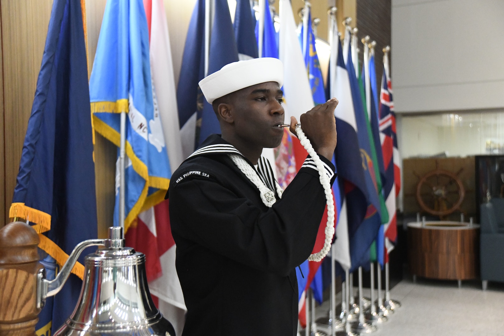 Boatswain's Mate Second Class Lorenzo Jordan pipes the bosun's whistle to symbolize the launch of MHS GENESIS at Naval Medical Center Camp Lejeune.