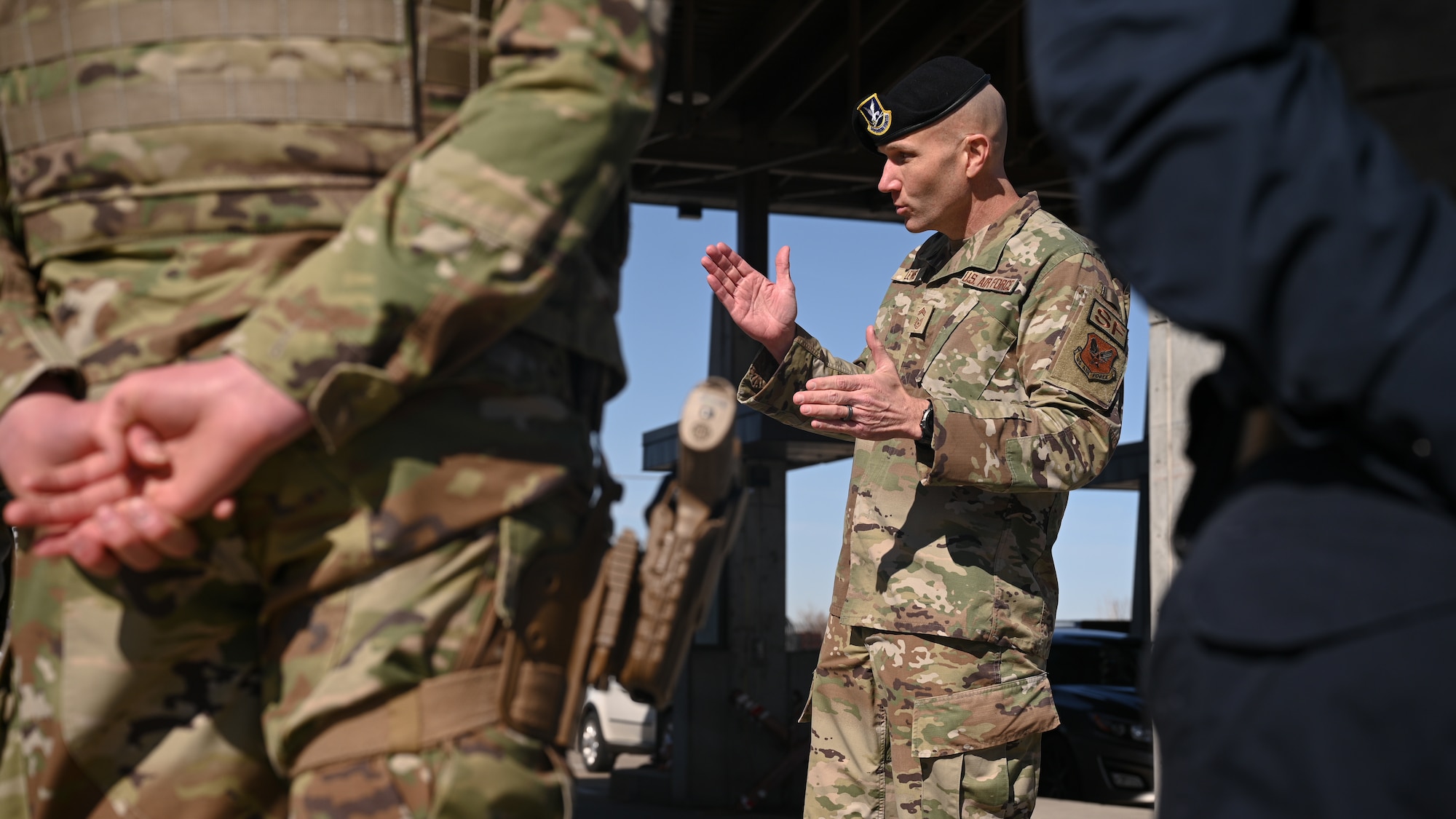 Chief Master Sgt. Brian Lewis speaks with Airmen standing at parade rest.