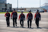 Members of the United States Army Special Operations Command parachute team, the Black Daggers, walk down the flight line in preparation for their jump to kick off the airshow at Naval Air Station Joint Reserve Base New Orleans, March 20, 2022.