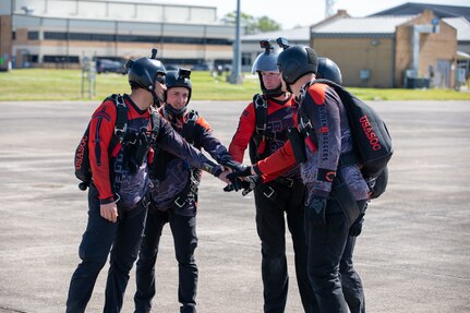 Members of the United States Army Special Operations Command parachute team, the Black Daggers,  do a team huddle before their jump to kick off the airshow at Naval Air Station Joint Reserve Base New Orleans, March 20, 2022.