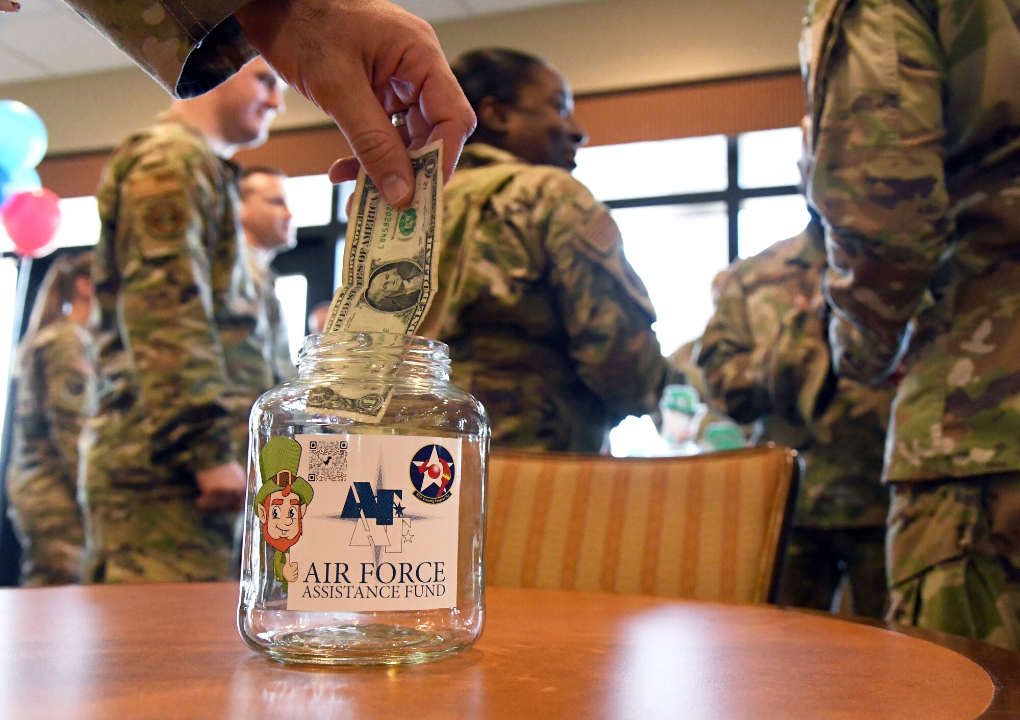 Keesler personnel make monetary donations during the Air Force Assistance Fund campaign kickoff event inside the Bay Breeze Event Center at Keesler Air Force Base, Mississippi, March 18, 2022. The AFAF campaign supports four charities that are dedicated to caring for Airmen and Guardians from induction through retirement and beyond. (U.S. Air Force photo by Kemberly Groue)