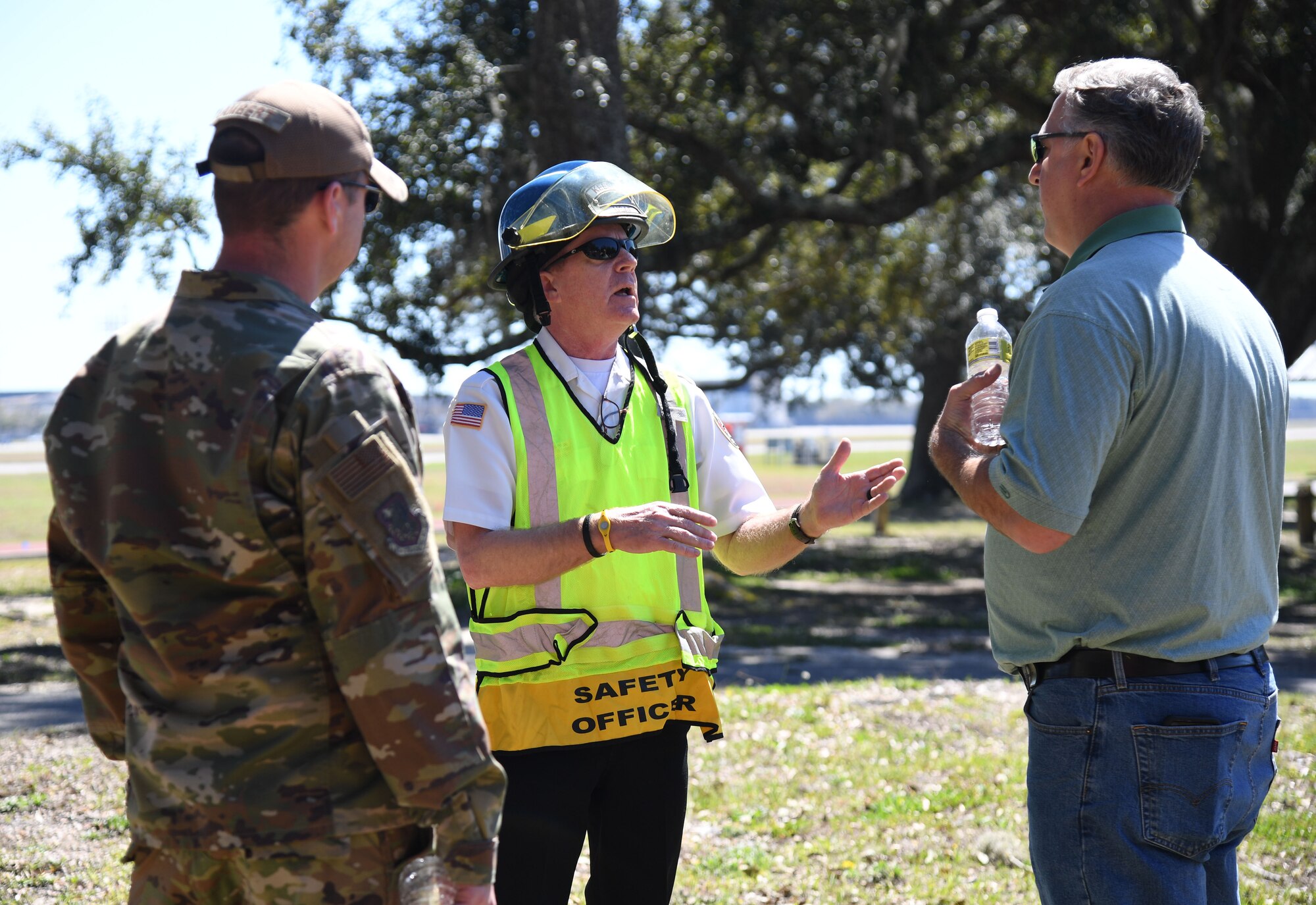 Gary Pierson, 81st Civil Engineering Squadron assistant fire chief, discusses the exercise scenario with U.S. Air Force Maj. Daniel Lambert, 81st Training Wing inspector general, and William Mays, 81st TRW inspections specialist, during an Antiterrorism, Force Protection and Chemical, Biological, Radiological, Nuclear exercise at Keesler Air Force Base, Mississippi, March 17, 2022. The exercise tested the base's ability to respond to and recover from a mass casualty event. (U.S. Air Force photo by Kemberly Groue)