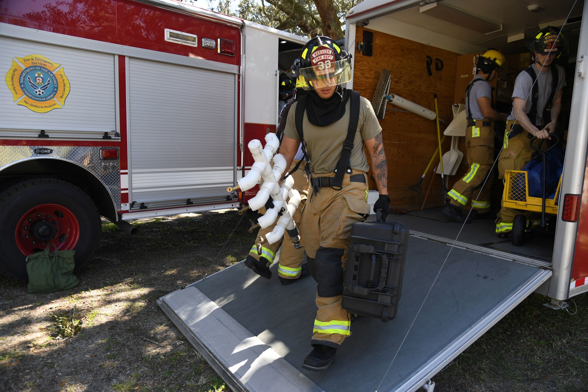 Members of the Keesler Fire Department gather equipment to set up a decontamination site during an Antiterrorism, Force Protection and Chemical, Biological, Radiological, Nuclear exercise at Keesler Air Force Base, Mississippi, March 17, 2022. The exercise tested the base's ability to respond to and recover from a mass casualty event. (U.S. Air Force photo by Kemberly Groue)