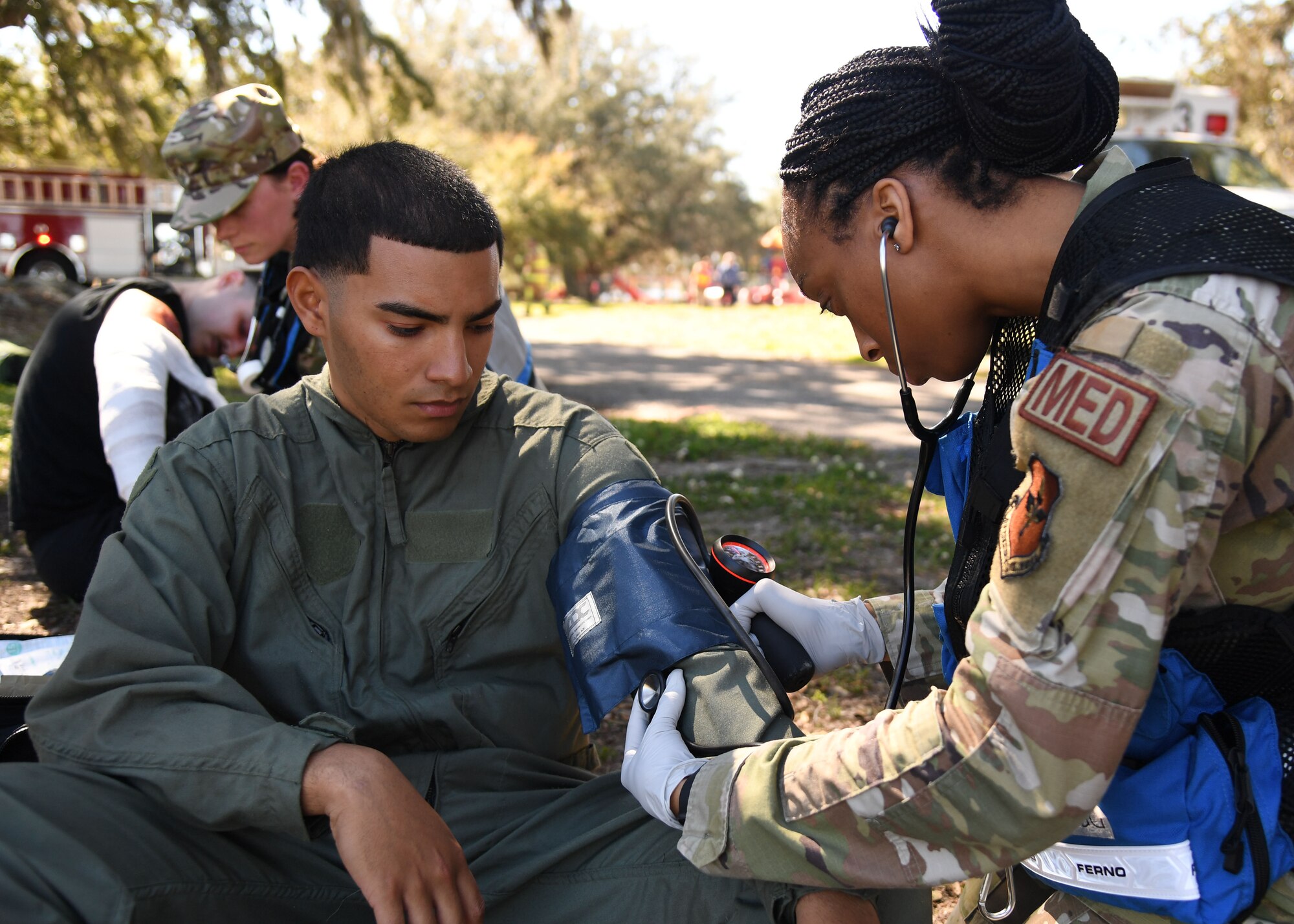 U.S. Air Force Staff Sgt. Monica Roundtree, 81st Operational Medical Readiness Squadron medical technician, checks vital signs on Airman Davion Robles, 334th Training Squadron student, as he portrays a victim during an Antiterrorism, Force Protection and Chemical, Biological, Radiological, Nuclear exercise at Keesler Air Force Base, Mississippi, March 17, 2022. The exercise tested the base's ability to respond to and recover from a mass casualty event. (U.S. Air Force photo by Kemberly Groue)