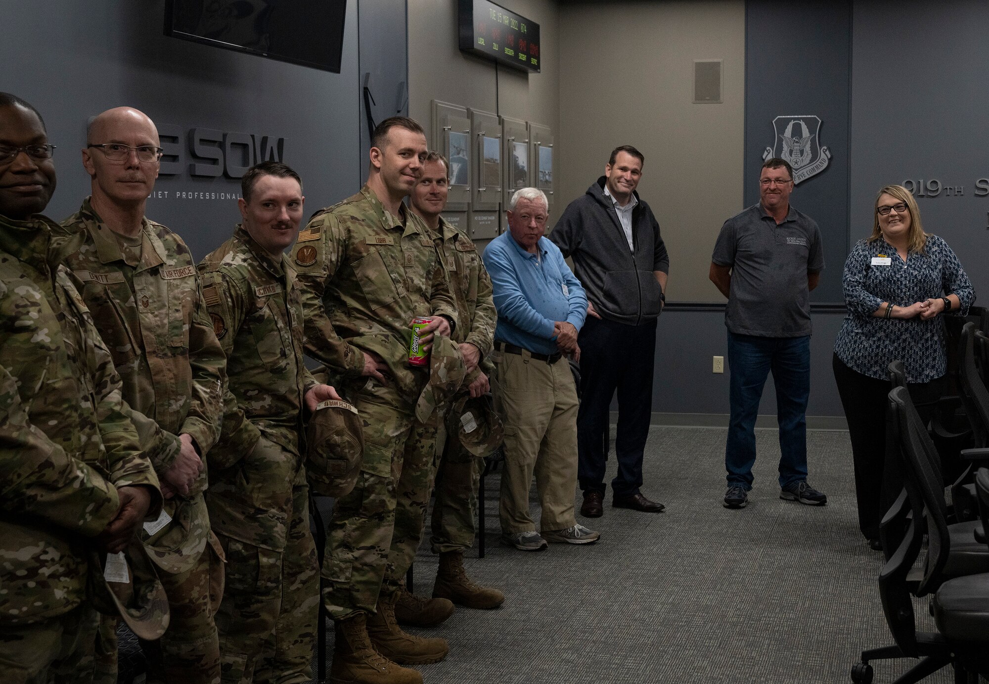 Airmen and local Navarre group stand in a room and chat