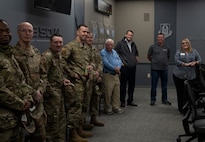 Airmen and local Navarre group stand in a room and chat