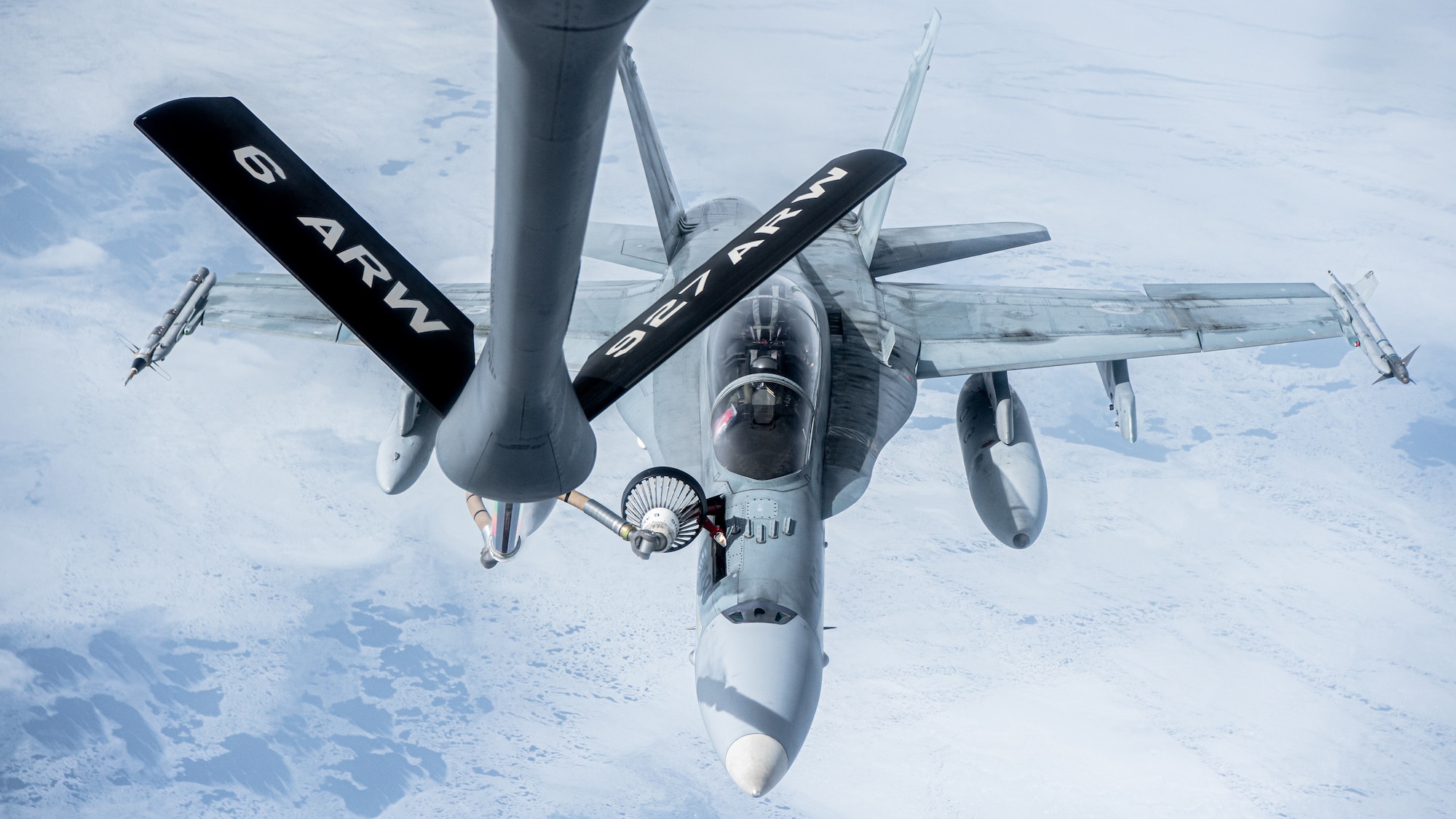 A KC-135 Stratotanker aircraft assigned to the 6th Air Refueling Wing provides aerial refueling for a CF-18 Hornet aircraft assigned to the 433rd Tactical Fighter Squadron in support of North American Aerospace Defense Command's (NORAD) Operation Noble Defender (OND), March 16, 2022.