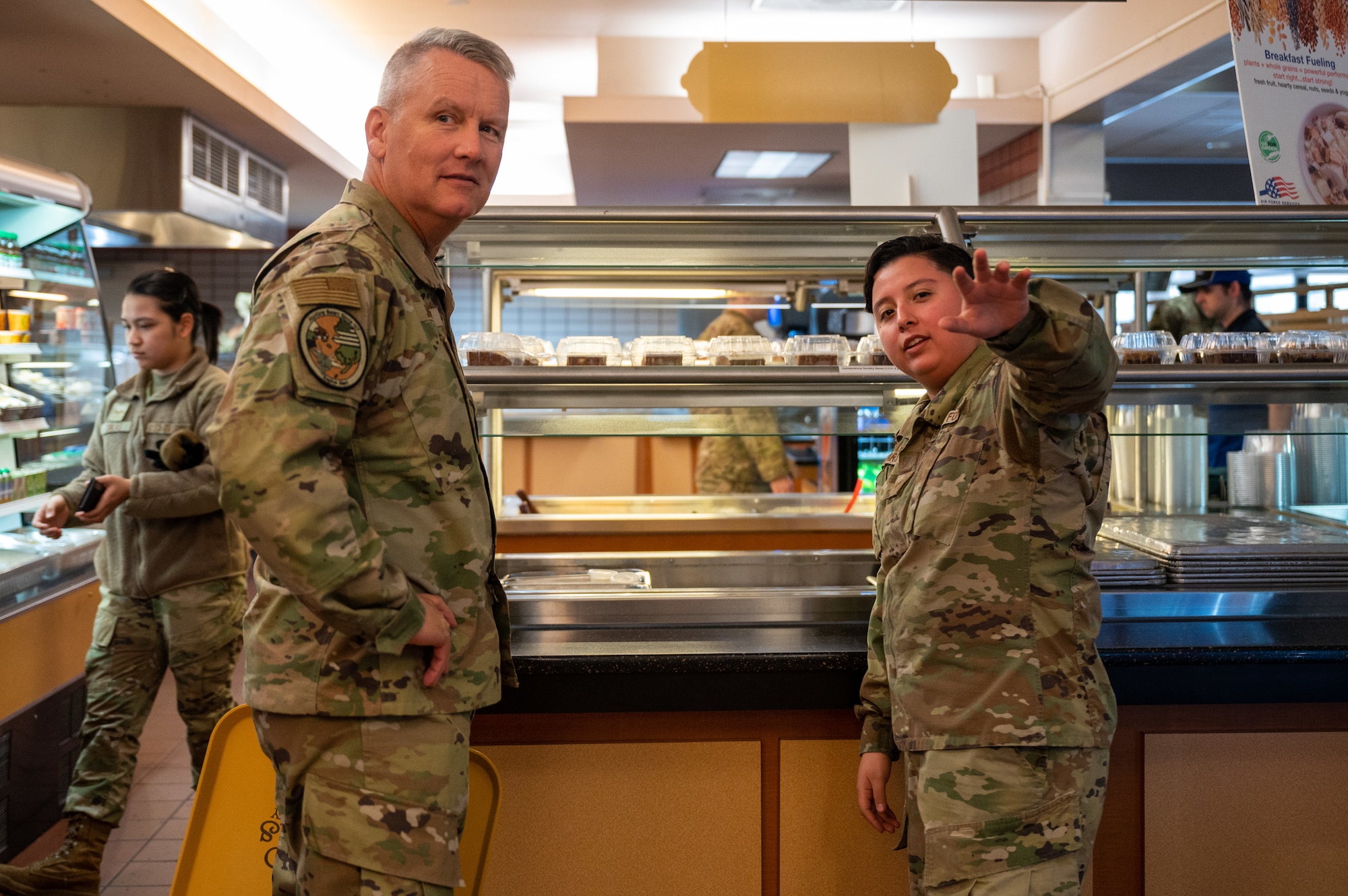 U.S. Air Force Senior Airman Victoria Camargo, a 354th Force Support Squadron assistant storeroom manager, discusses food options at the Two Seasons Dining Hall with Lt. Gen. James Jacobson, U.S. Pacific Air Forces deputy commander, during a visit to Eielson Air Force Base, Alaska, March 9, 2022.
