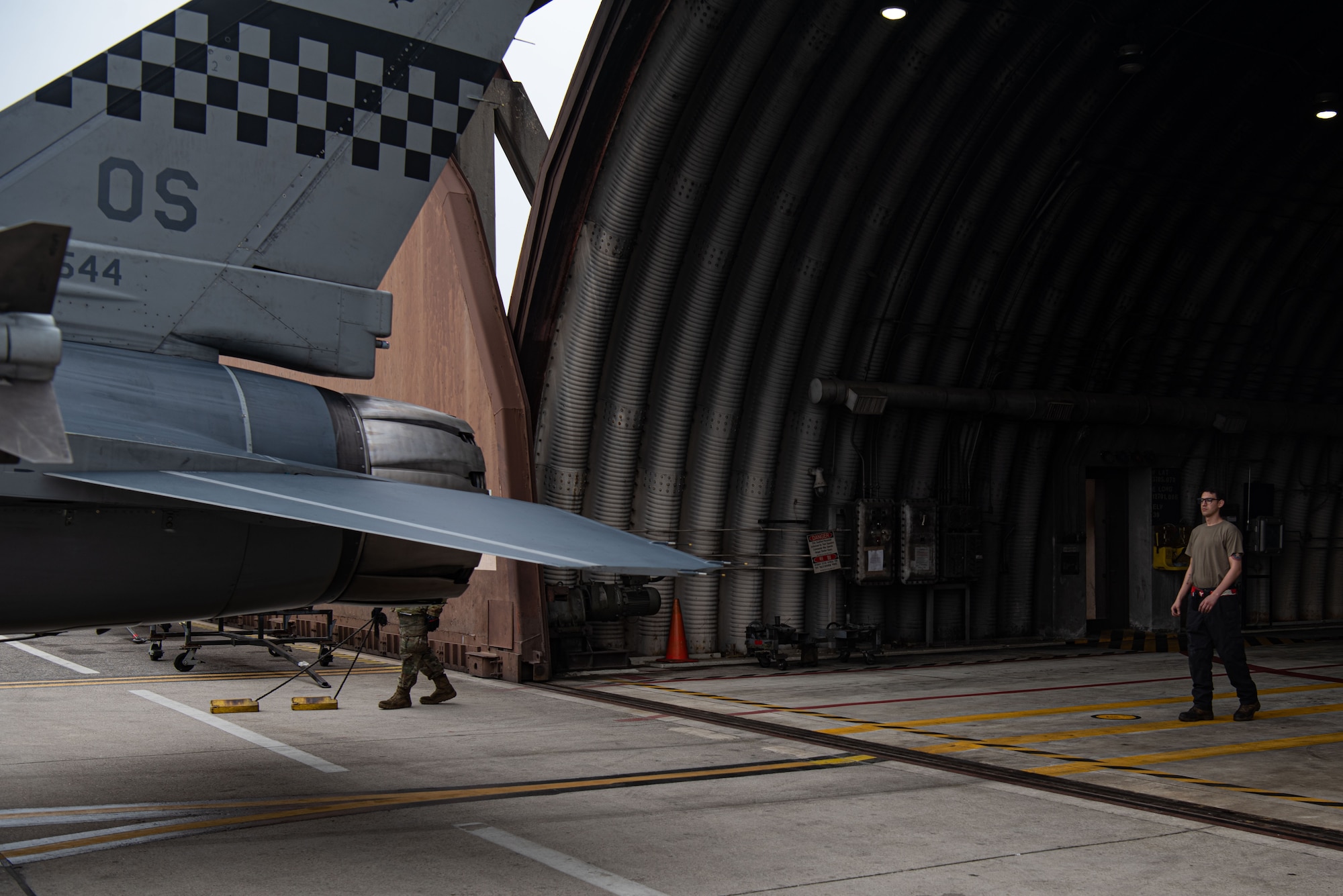 Staff Sgt. Armando Sutton, 36th Aircraft Maintenance Unit F-16 dedicated crew chief, assists in parking an F-16 Fighting Falcon in a hangar at Osan Air Base, Republic of Korea, March 18, 2022.