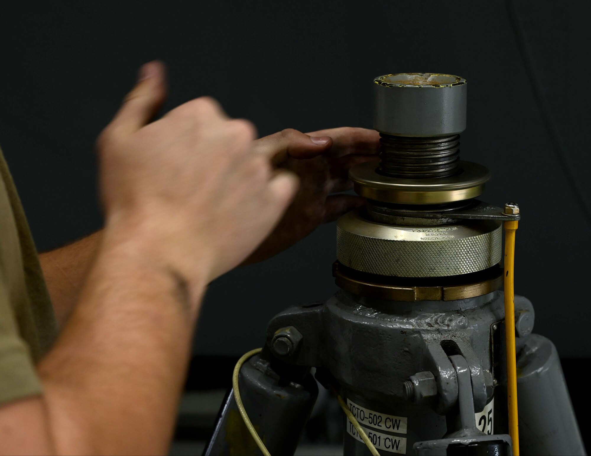 a man raises the jack screw on a fuselage jack