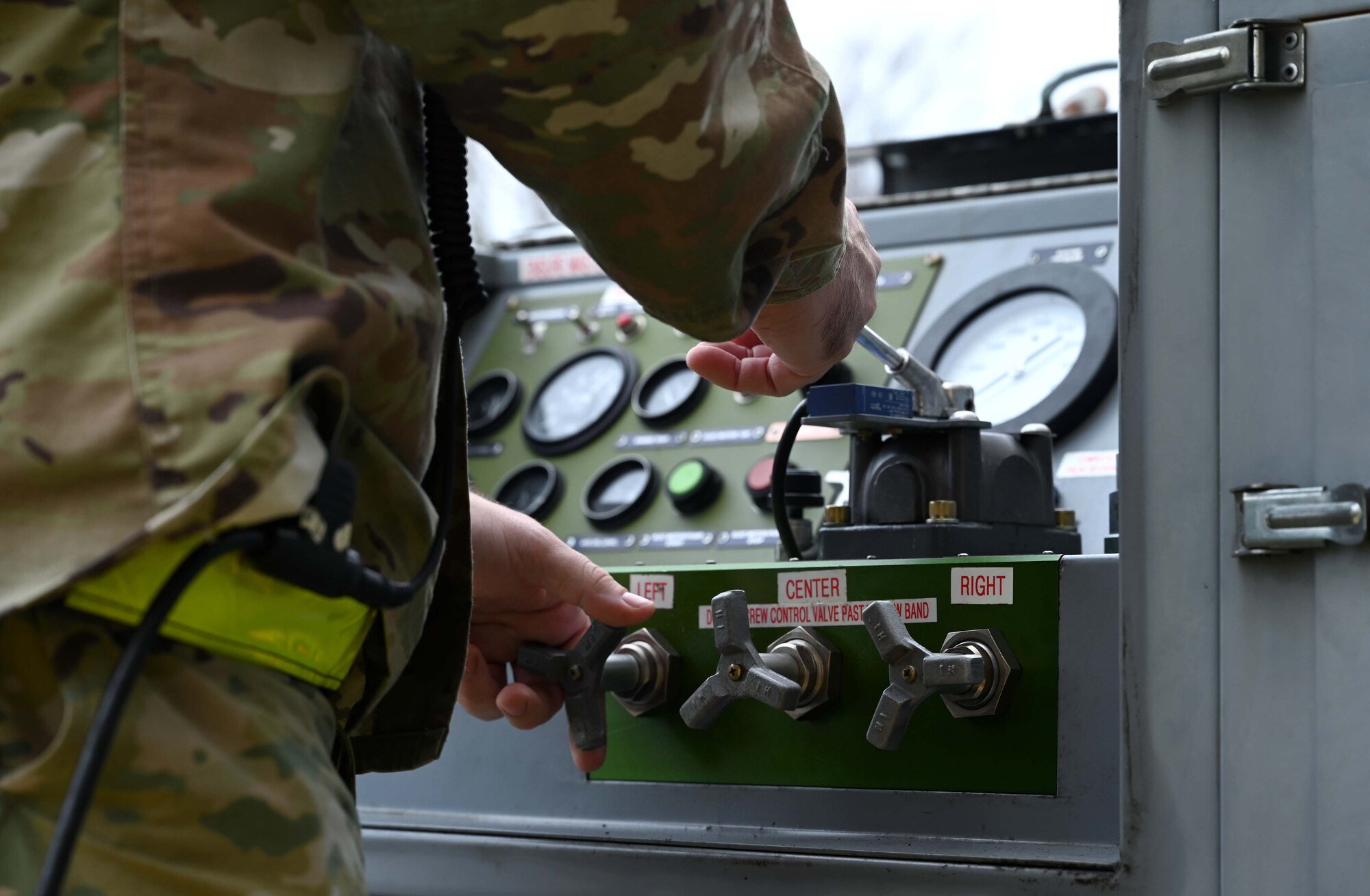 a man adjusts the the pressure output on a jacking manifold.