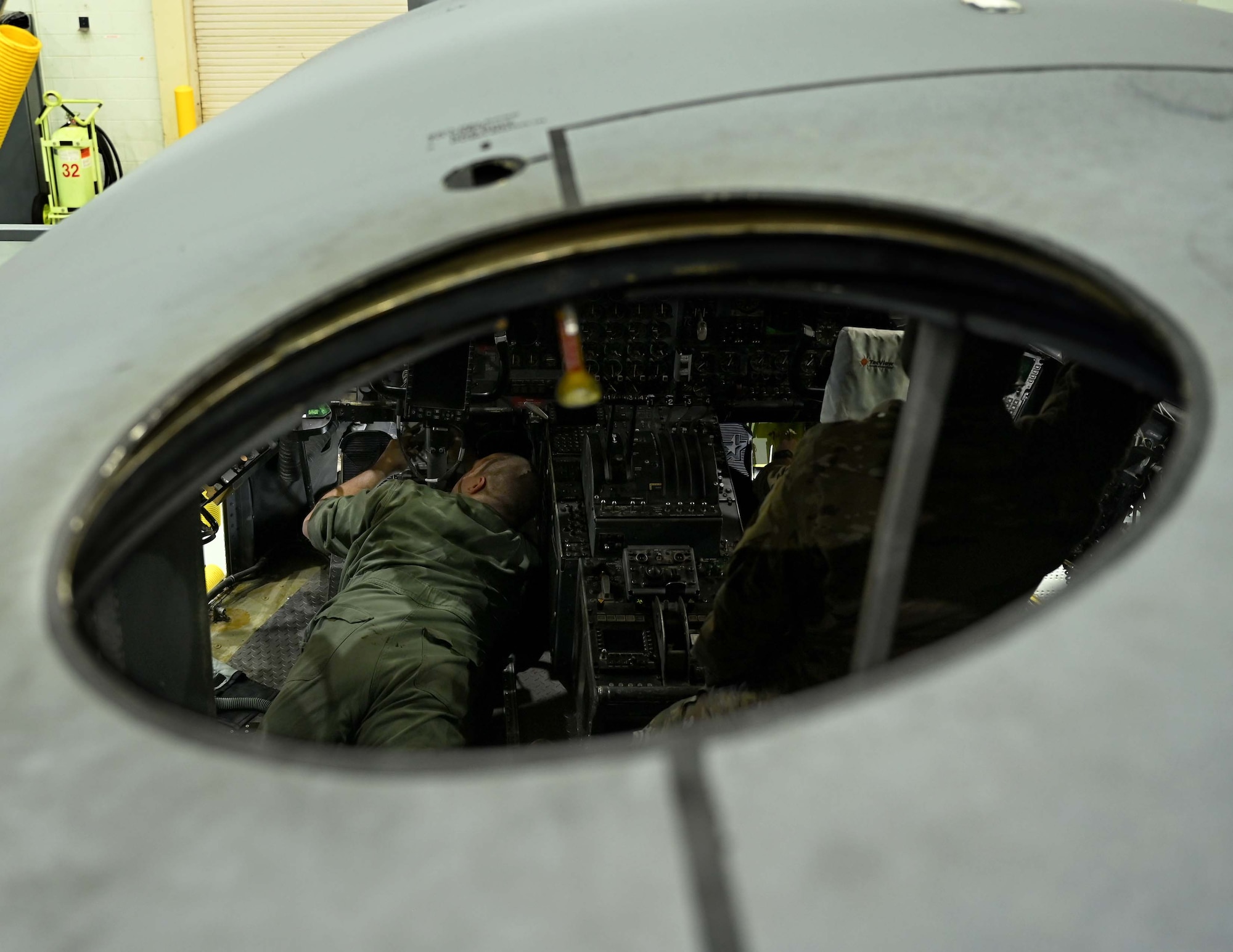 a man adjusts the needle bearings of a rudder pedal linkage.