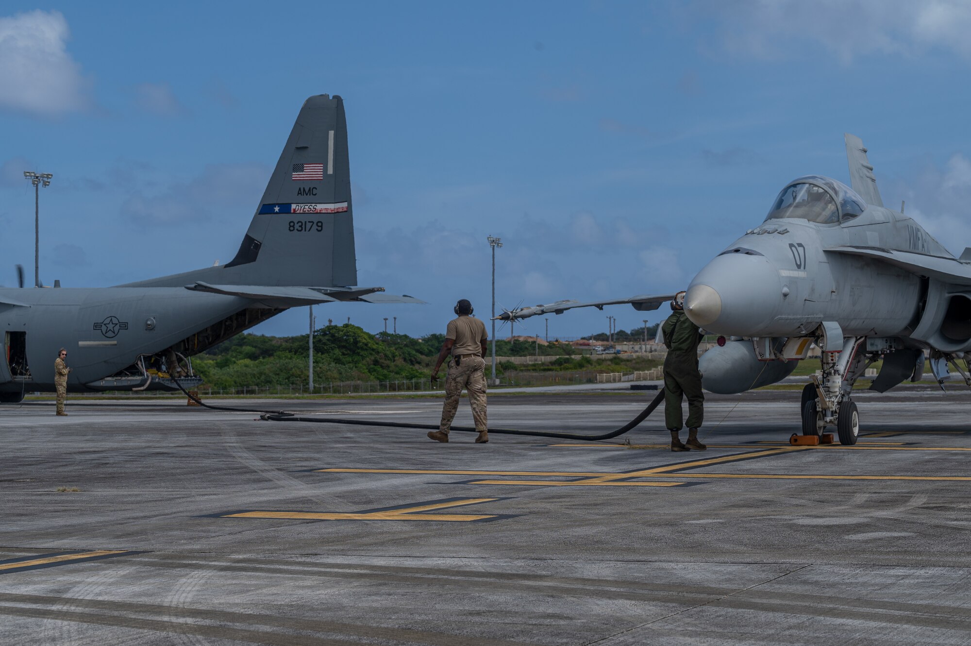 A C-130J fuels a F/A-18C Hornet during a hot pit refueling at Andersen Air Force Base, Guam, Feb. 14, 2022.