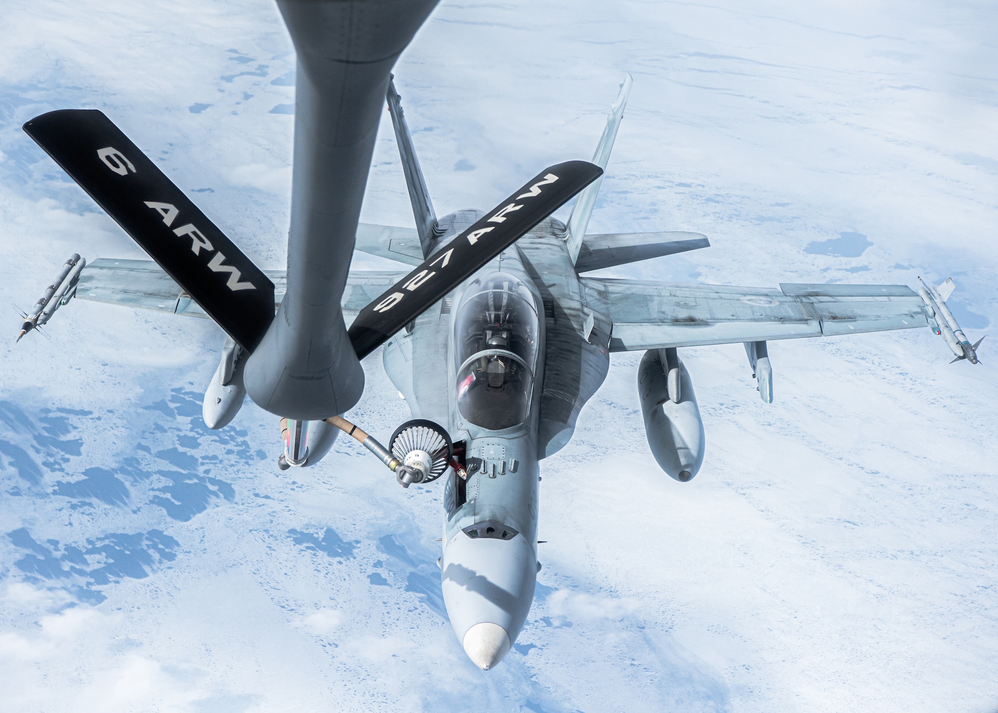 A KC-135 Stratotanker aircraft assigned to the 6th Air Refueling Wing provides aerial refueling for a CF-18 Hornet aircraft assigned to the 433rd Tactical Fighter Squadron in support of North American Aerospace Defense Command's (NORAD) Operation Noble Defender (OND), March 16, 2022.