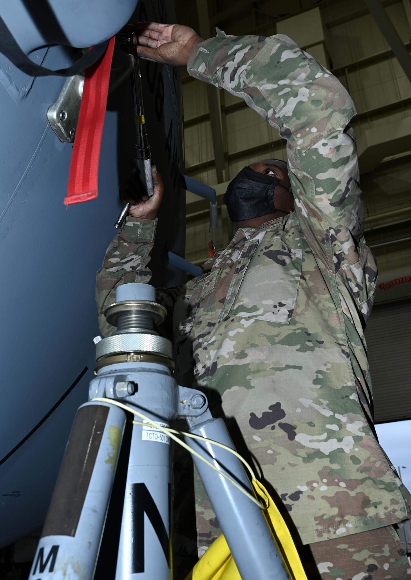 a man uses a torque wrench on an aircraft jack pad