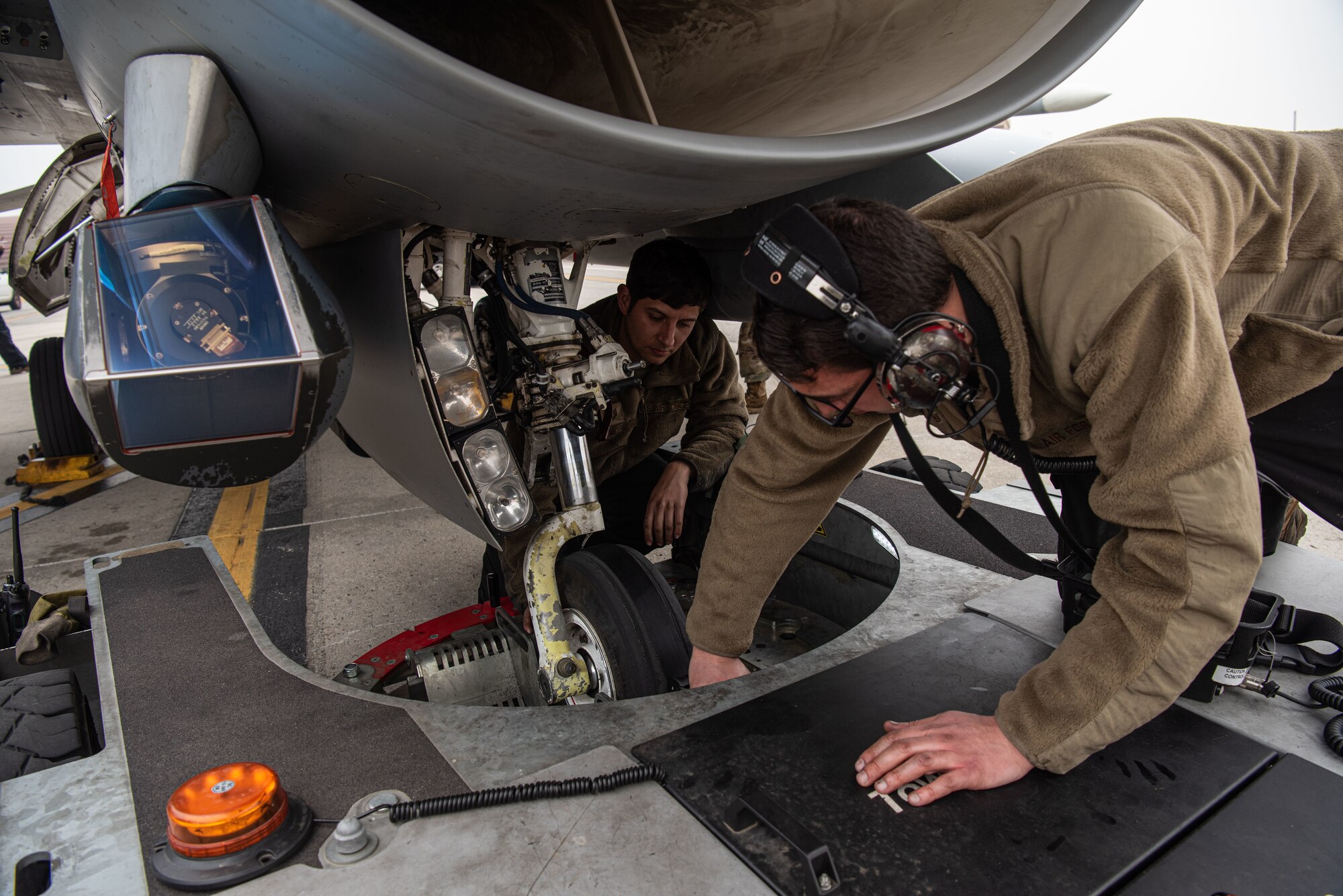 Tech. Sgt. Jose Corral DeLeon, 36th Aircraft Maintenance Unit, cannibalization manager, left, and Staff Sgt. Armando Sutton, 36th AMU F-16 Fighting Falcon dedicated crew chief, right, ensure an F-16 is connected to a TowFLEXX at Osan Air Base, Republic of Korea, March 18, 2022.