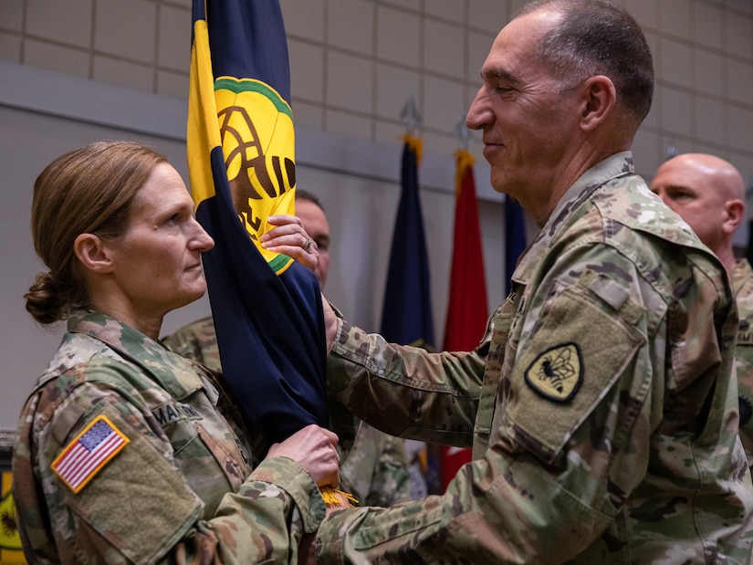Lt. Col. Eric Wiedmeier, the incoming commander of 97th Troop Command, accepts the 97th TC colors from Brig. Gen. Tyler Smith during the change-of-command ceremony