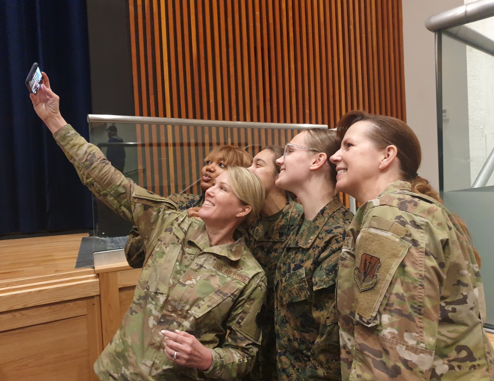 A group of women wearing military uniforms pose for a picture.